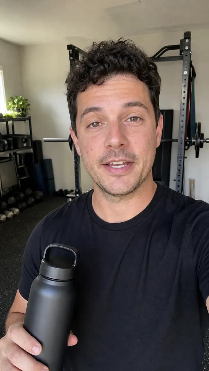 Ethan C. holding a water bottle in a home gym